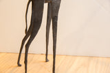 Slender legs and curving tail of the large vintage African giraffe figure.