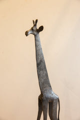 Angled view of the vintage African giraffe's sculpted head and neck, showing its dark, textured patina.