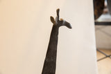Side profile of the vintage African giraffe sculpture's textured dark head.