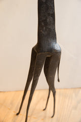 Dark, textured lower body and slender legs of the vintage African giraffe sculpture.