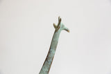 Vintage African giraffe head and neck detail, showing green-blue patina and textured spots.