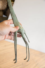 Vintage African giraffe sculpture's slender legs, showcasing aged green-bronze patina and texture.