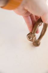 Geometric block terminal of the copper cuff showing etched details and patina.