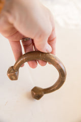Antique African copper bracelet held to show its thick, curved shape.