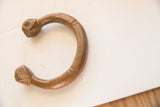 Curved profile of an antique African copper snake cuff with faceted, sculpted ends.