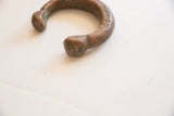 Rounded terminal end of the antique copper snake cuff with an aged patina.