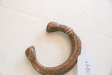Antique African copper bracelet showing hand-punched details and attached shop tag.