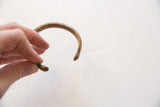 Detail of the antique bronze cuff's inner curve and stamped dot pattern.