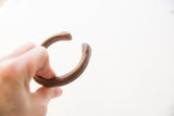 View of the antique copper cuff's opening and its aged, smooth patina.