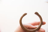 View of the antique African cuff's opening, held to show scale.