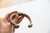 Side view of the antique bronze cuff, highlighting its substantial form and wrist opening.