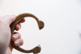 Antique bronze snake cuff held in hand, showing its scale and C-shaped opening.