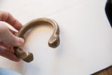 Antique African bronze cuff held to show its substantial form and faceted end.