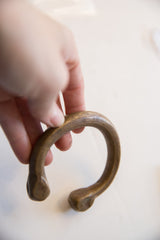Etched details and aged patina along the curve of the antique bronze snake cuff.