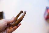 Antique African bronze cuff bracelet held in hand, showing its smooth, aged patina.