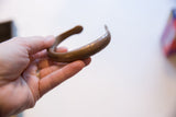Antique African bronze snake cuff held to show its scale and warm patina.