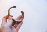 Side view of the antique bronze snake cuff bracelet showing its curved form.
