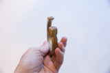Profile view of the antique bronze snake cuff's opening and smooth, worn texture.
