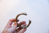 Antique bronze snake cuff bracelet held to show its solid, sculptural form.