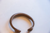 Angled view of the antique copper snake cuff's open design and textured band.