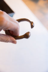View of the antique African cuff's opening with two stylized snake heads.
