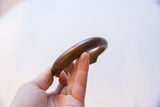 Close view of the antique copper cuff's curved form and detailed inner rim.