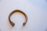 The textured, stamped pattern along the curve of the antique African bronze cuff.