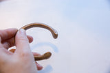 Hand-etched crescent scale pattern along the curved body of the antique bronze cuff.