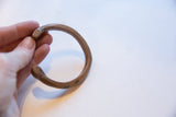 Side profile of the antique bronze cuff showing its curved form and aged surface.