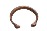 Antique African copper alloy snake cuff bracelet displaying a dark, warm patina.