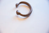 Angled profile of the antique copper snake cuff's open form and texture.