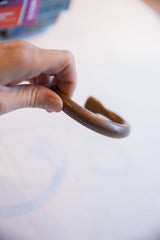 Curved profile of the antique African copper bracelet showing its warm, smooth surface patina.