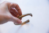 Antique bronze snake cuff bracelet held in hand, showing its scale and aged patina.