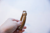 Close-up view of the antique bronze cuff's rounded end, showing its aged patina.
