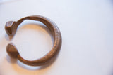 Angled view of the antique bronze snake cuff showing its open shape and etched details.