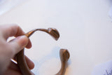 View of the open ends of the antique bronze snake cuff, showing stylized terminals.