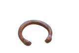 Antique African copper alloy snake cuff bracelet with a ribbed texture and aged patina.