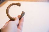 Profile of an antique African copper cuff showing its shape and stamped terminals.