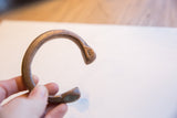The stamped terminal and aged copper surface of an African snake cuff.
