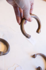 A view of the antique copper cuff's curved form and incised surface markings.
