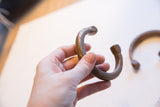 The curved body of the African snake cuff showing its aged patina and incised details.