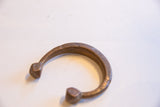 Angled view of an antique African cuff showing incised patterns and a warm patina.