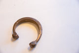 Angled view of an antique African snake cuff showing its textural details and patina.