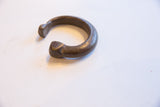 Aged patina and etched details on the stylized head of the antique bronze cuff.