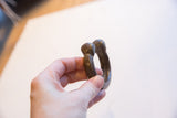 The antique bronze snake cuff bracelet held in hand to demonstrate its size and form.