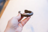 Holding the substantial antique African bronze snake cuff to show its scale.