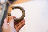 Antique bronze snake cuff bracelet held to display its size and shape.