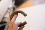 Antique bronze snake cuff bracelet held to show its open C-shape and etched terminals.
