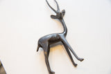 Vintage African gazelle's dark, textured body and slender hind legs.