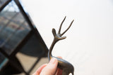 Hand-held vintage African gazelle sculpture with a dark metal finish and distinct antlers.